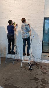 women installing art